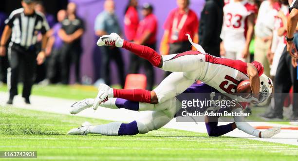 KeeSean Johnson of the Arizona Cardinals gets tackled by Kris Boyd of the Minnesota Vikings in the fourth quarter of preseason play at U.S. Bank...