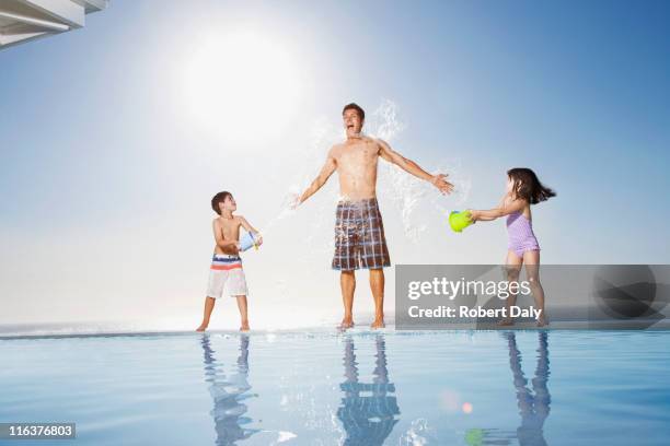 children splashing water on man - throwing water stock pictures, royalty-free photos & images