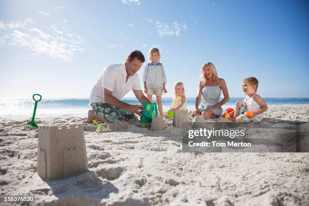 famille, faire des châteaux de sable sur la plage - château de sable photos et images de collection