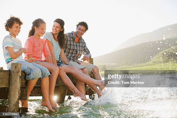 family on dock splashing feet in lake - tween heels stock pictures, royalty-free photos & images