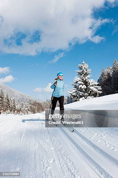 germany, bavaria, aschermoos, senior woman doing cross-country skiing - bayern winter stock-fotos und bilder