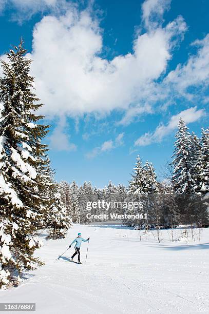 germany, bavaria, aschermoos, senior woman doing cross-country skiing - bayern winter stock-fotos und bilder