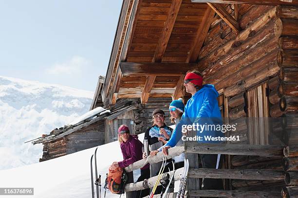 italy, trentino-alto adige, alto adige, bolzano, seiser alm, people standing outside ski resort near railings - alpen berghütte stock-fotos und bilder