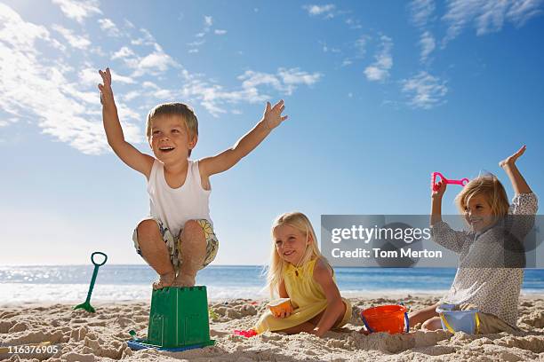 kids playing on beach - beach bucket stock pictures, royalty-free photos & images