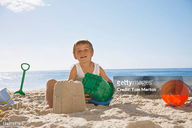 junge sie eine sandburg am strand - sandburg stock-fotos und bilder