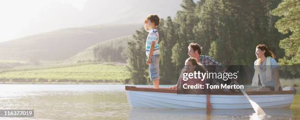 familia en barco de remos en el lago - agua estancada fotografías e imágenes de stock