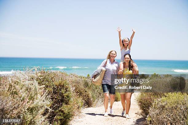 grandmother with daughter and granddaughter on beach path - grandmother walking stock pictures, royalty-free photos & images