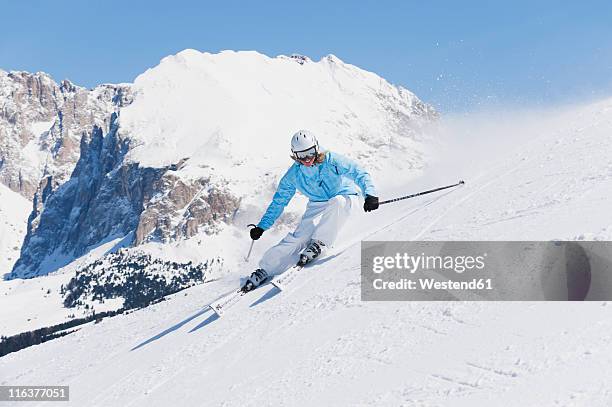 italy, trentino-alto adige, alto adige, bolzano, seiser alm, young woman skiing near mountain - seiser alm stock-fotos und bilder