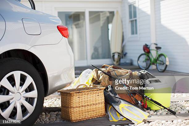 picnic basket, fishing rod, flippers and bags outside car in driveway - sports equipment stock pictures, royalty-free photos & images