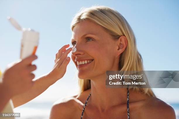 girl applying sunscreen to mothers nose - girl hold nose stock pictures, royalty-free photos & images