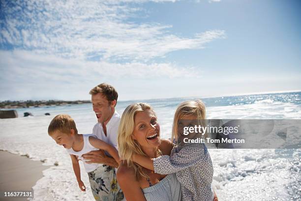 family playing on beach - boy happy blonde stock pictures, royalty-free photos & images