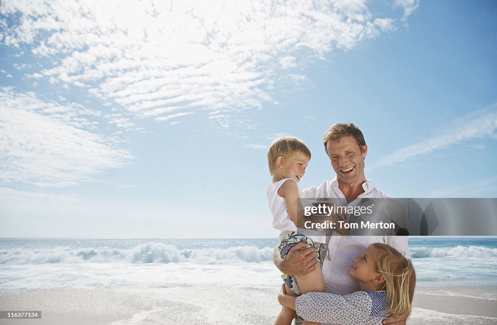 Father with daughter and son on beach