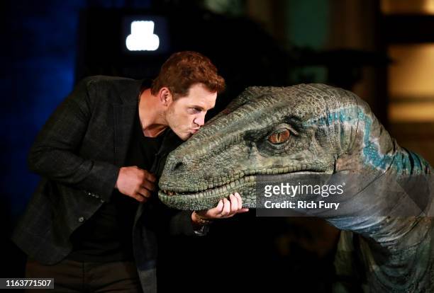Chris Pratt and Blue the velociraptor interact onstage at the grand opening celebration of 'Jurassic World -The Ride' at Universal Studios Hollywood...