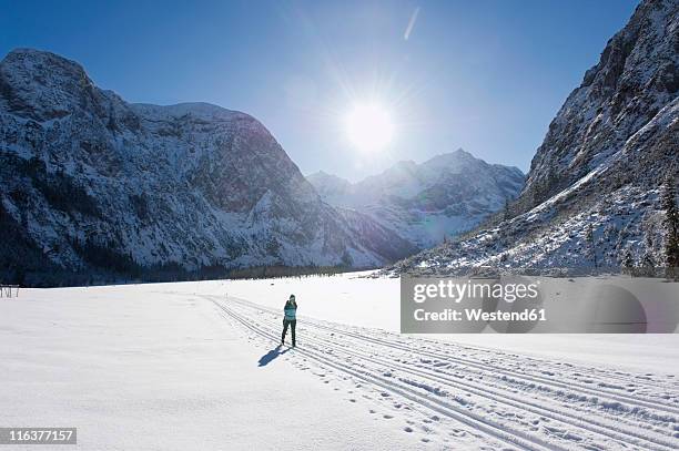 germany, bavaria, senior woman doing cross-country skiing with karwendal mountains in background - karwendel stock pictures, royalty-free photos & images