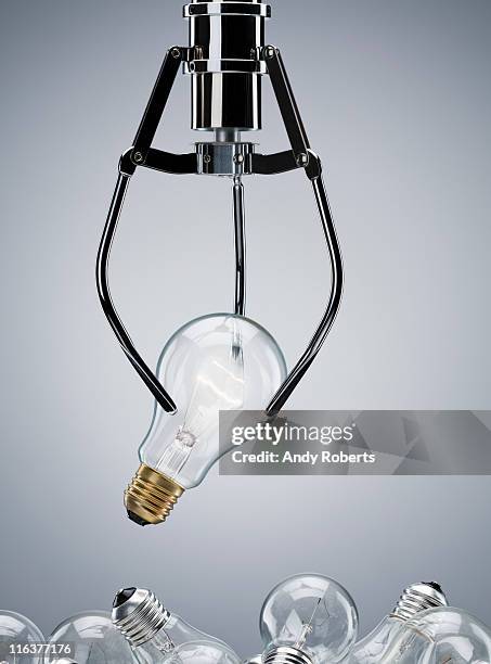 mechanical claw lifting light bulb - griffes ou pinces photos et images de collection