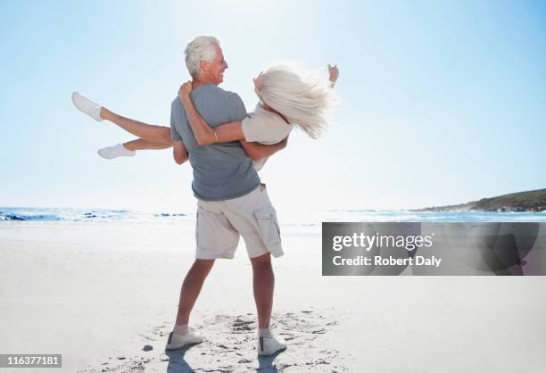 mann spinning frau am strand - senior life active stock-fotos und bilder