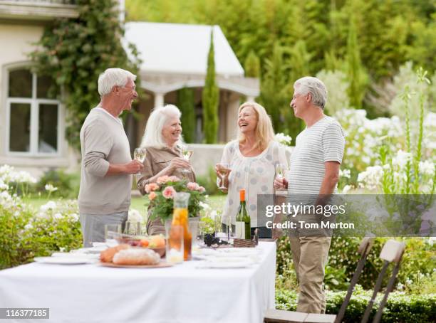 couples drinking wine in garden - standing table outside stock pictures, royalty-free photos & images