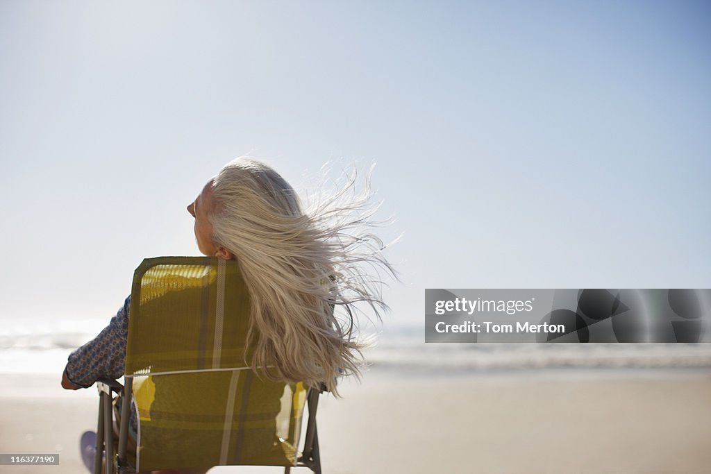 Womans soffiatura dei capelli nel vento sulla spiaggia