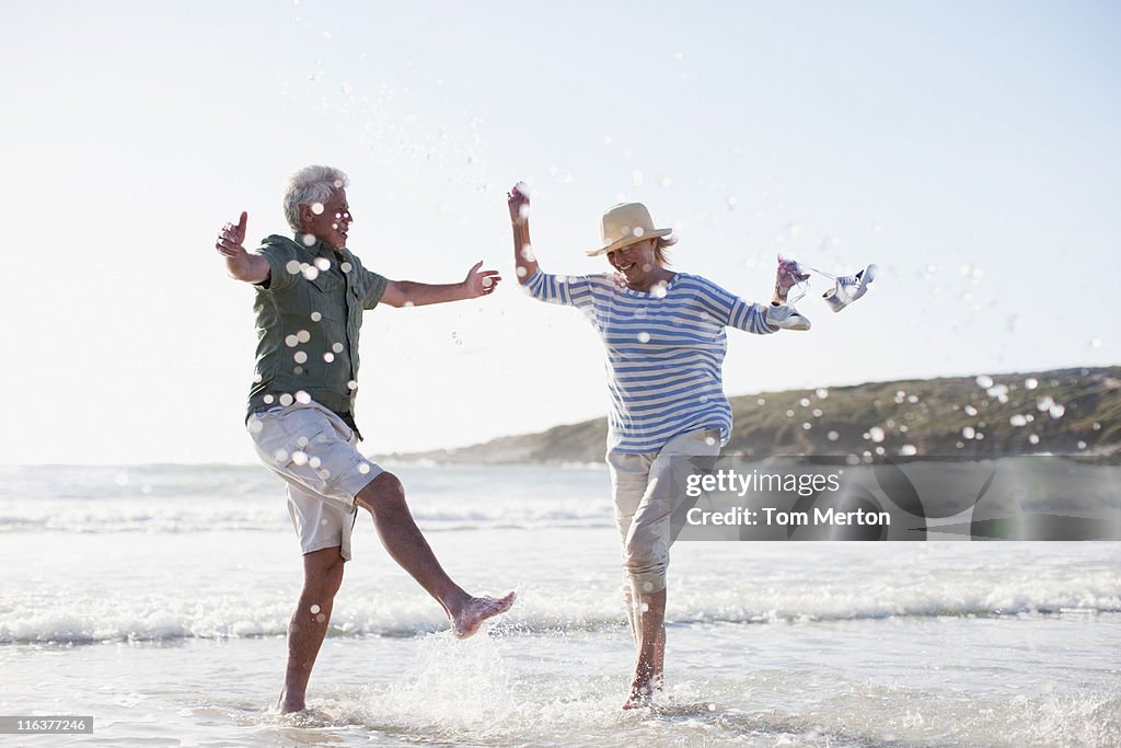 Senior couple splashing in ocean