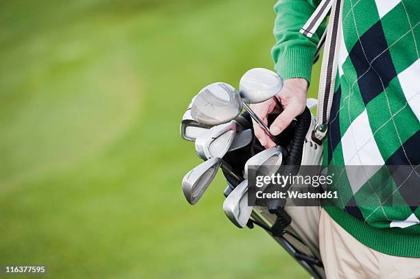 italy, kastelruth, mature man with carrying golf bag, close up - bolsa de golf fotografías e imágenes de stock