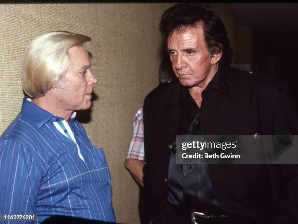 Country Music Singer Songwriter George Jones & Johnny Cash talk back stage at Opry House on January 1, 1991 in Nashville, Tennessee