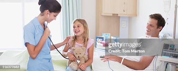 krankenschwester mit vater und tochter im krankenhaus - kind teddy sitzt stock-fotos und bilder