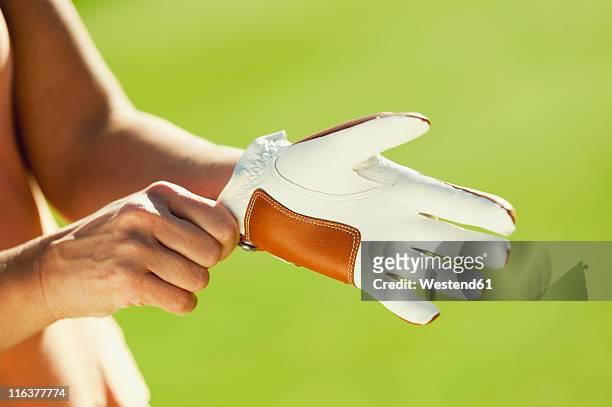 italy, kastelruth, mid adult woman wearing golf glove - golfhandschuh stock-fotos und bilder