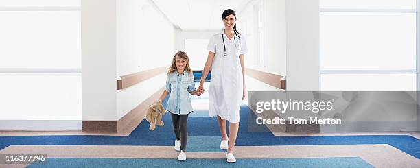 nurse and girl patient in hospital corridor - doctor stethoscope patient whole body stock pictures, royalty-free photos & images