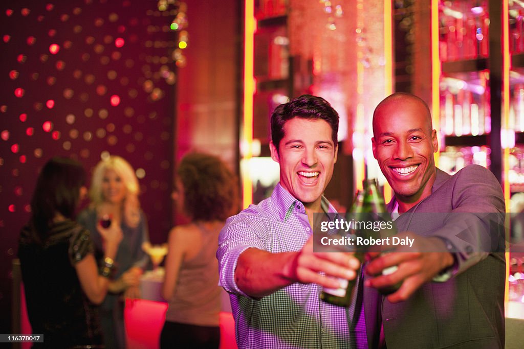 Männer rösten Bierflaschen in den Nachtclub