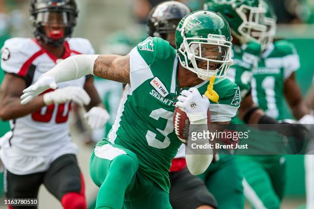 Nick Marshall of the Saskatchewan Roughriders runs with the ball after making an interception in the game between the Ottawa RedBlacks and...