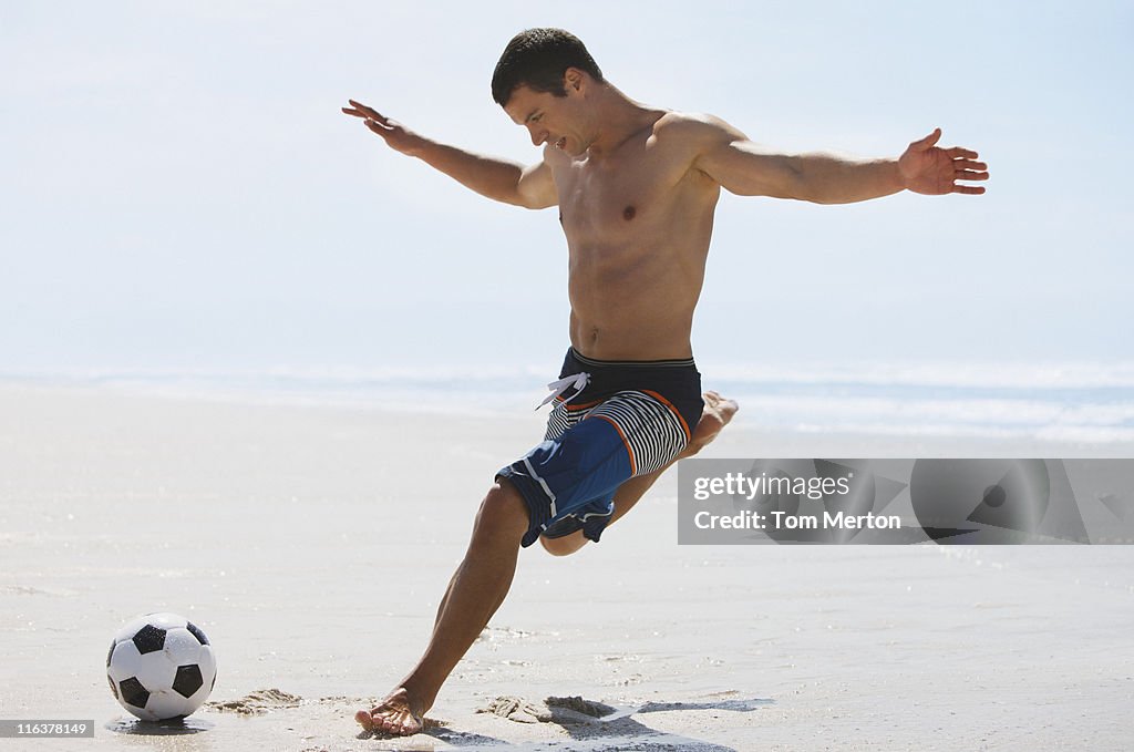 Hombre gritando pelota de fútbol en la playa