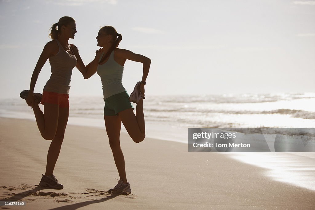 Friends stretching on beach