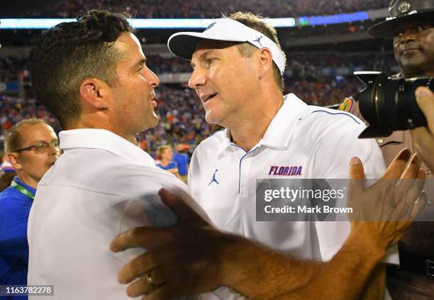 Head Coach Manny Diaz of the Miami Hurricanes and Head coach Dan Mullen of the Florida Gators shake hands after the game at the Camping World Kickoff...