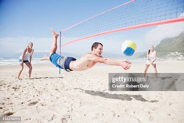 friends playing volleyball on beach - beach volleyball stock pictures, royalty-free photos & images