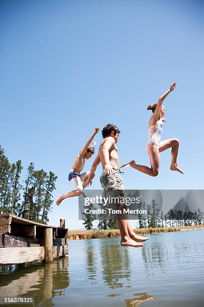 kids jumping in lake - vertical jump stock pictures, royalty-free photos & images