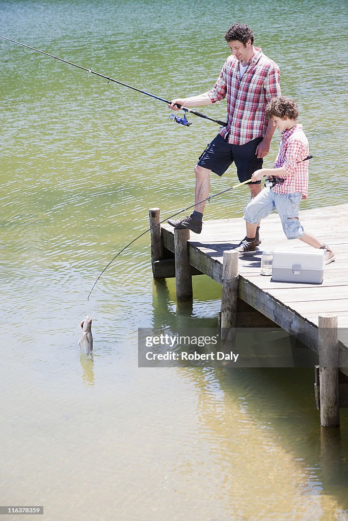 Father and son fishing off dock