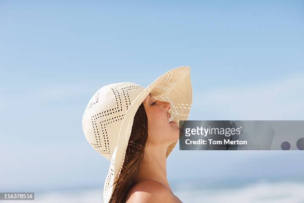 woman wearing sun hat - beach hat stock pictures, royalty-free photos & images