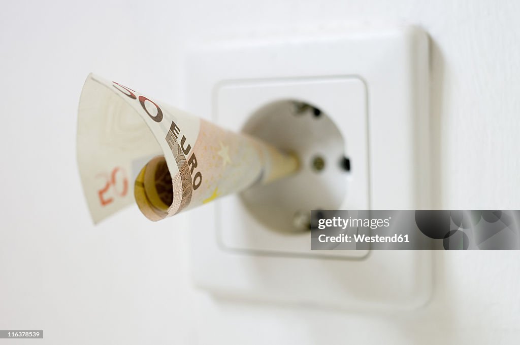 50 euro note kept into electrical socket, close up