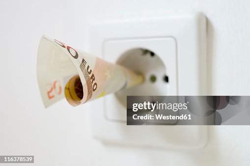 50 euro note kept into electrical socket, close up 50 euro note kept into electrical socket, close up