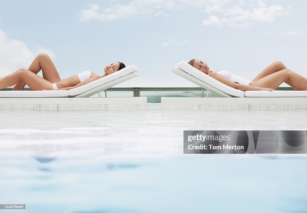 Frau Sonnenbaden in Liegestühlen am Pool