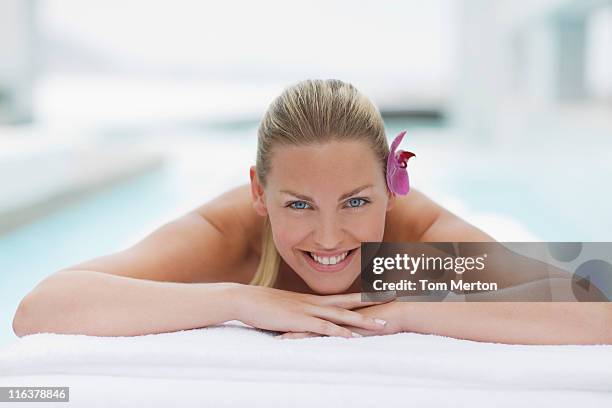 femme jeter sur la table de massage au bord de la piscine - allongé sur le devant photos et images de collection