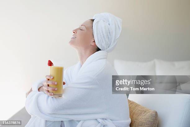 woman in bathrobe drinking smoothie - robe stock pictures, royalty-free photos & images
