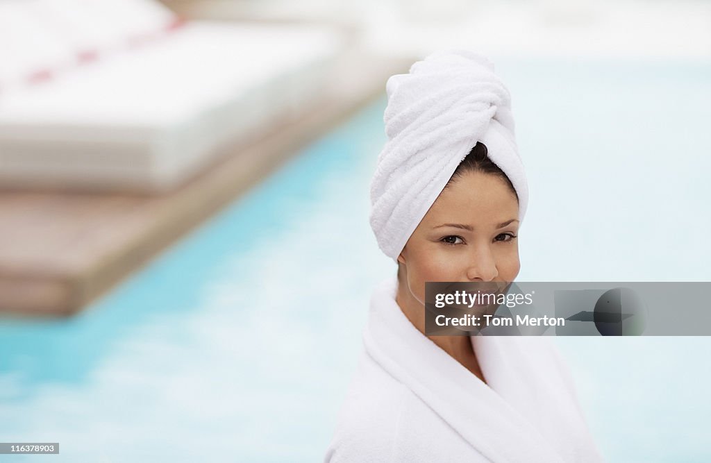 Woman with head wrapped in towel at poolside