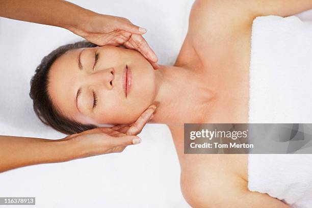 woman receiving facial massage - beauty salon stockfoto's en -beelden