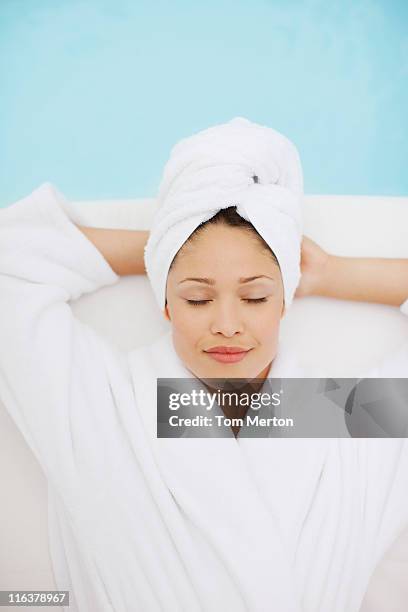 woman with head wrapped in towel laying at poolside - woman spa towel stock pictures, royalty-free photos & images