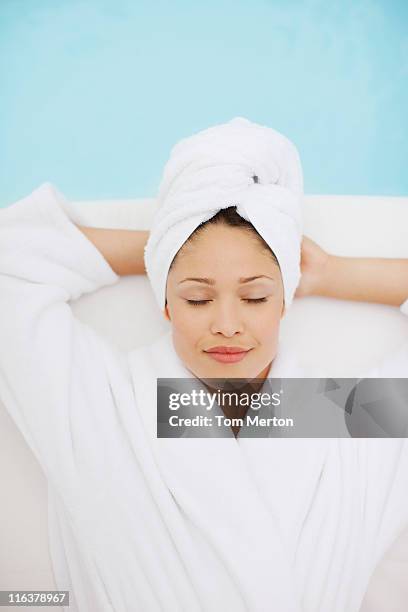 woman with head wrapped in towel laying at poolside - health spa stock pictures, royalty-free photos & images