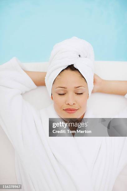 woman with head wrapped in towel laying at poolside - bathrobe 個照片及圖片檔