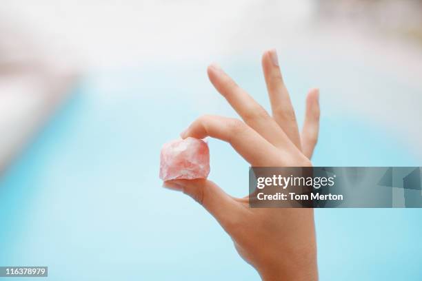 hand holding crystal at poolside - rose quartz stock pictures, royalty-free photos & images