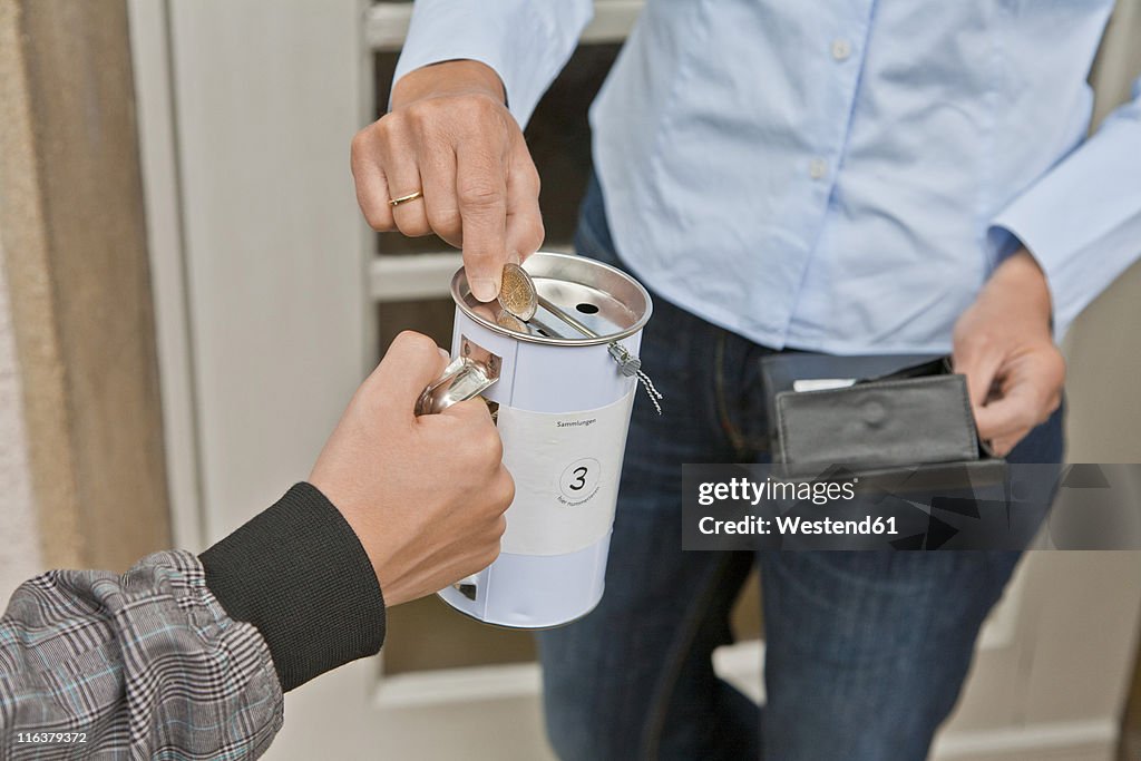 Teenage boy donating money at door