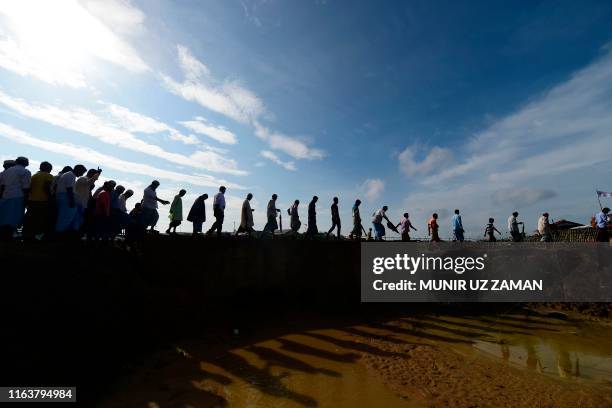 Rohingya refugees arrive to attend a ceremony organised to remember the second anniversary of a military crackdown that prompted a massive exodus of...